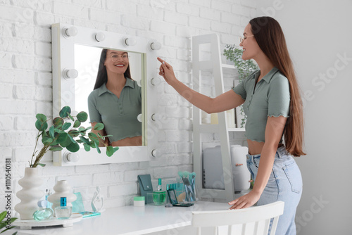 Young woman near mirror in ...
