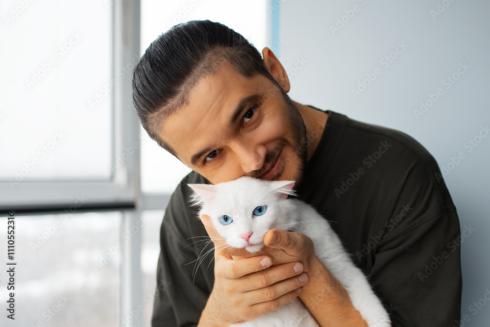 Portrait of young happy man hugging white fluffy cat with blue eyes. Portrait of young happy man hugging white fluffy cat with blue eyes.