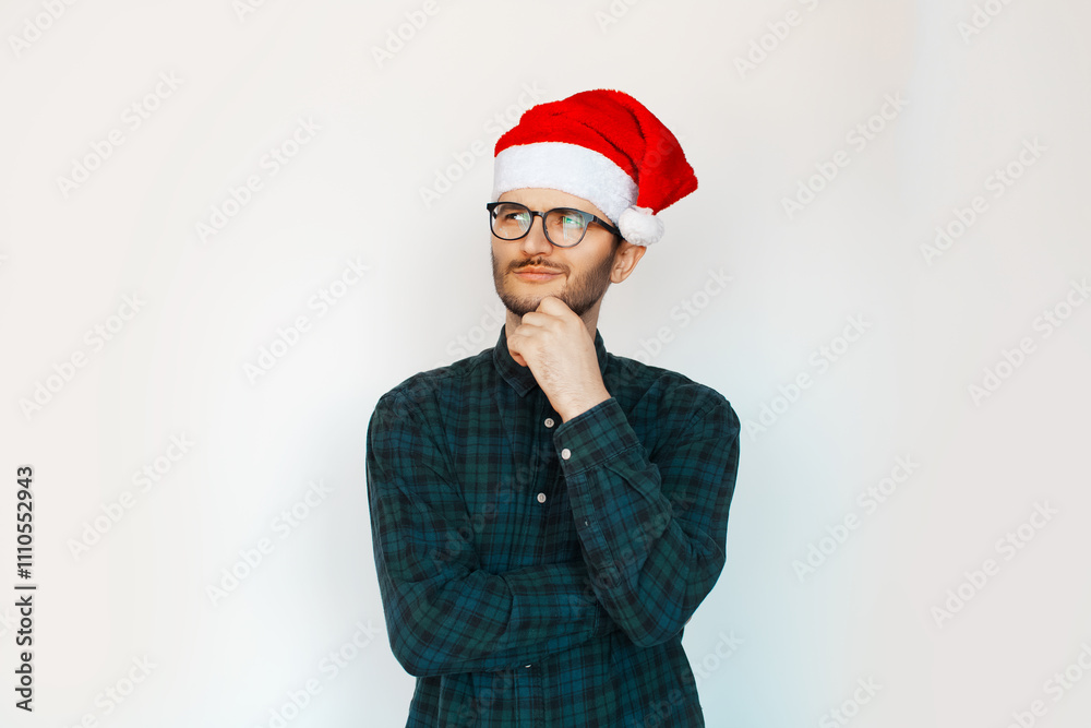 Portrait of young thoughtful man in Santa hat on white background. Portrait of young thoughtful man in Santa hat on white background.
