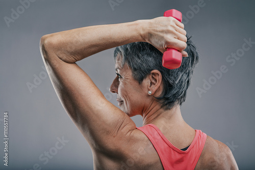 Senior woman lifting weights, maintaining fitness and health