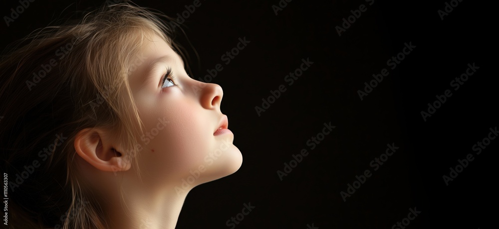 Girl gazing upwards, soft lighting, serene expression, youthful innocence, profile view, dark background, copy space for text Girl gazing upwards, soft lighting, serene expression, youthful innocence, profile view, dark background, copy space for text