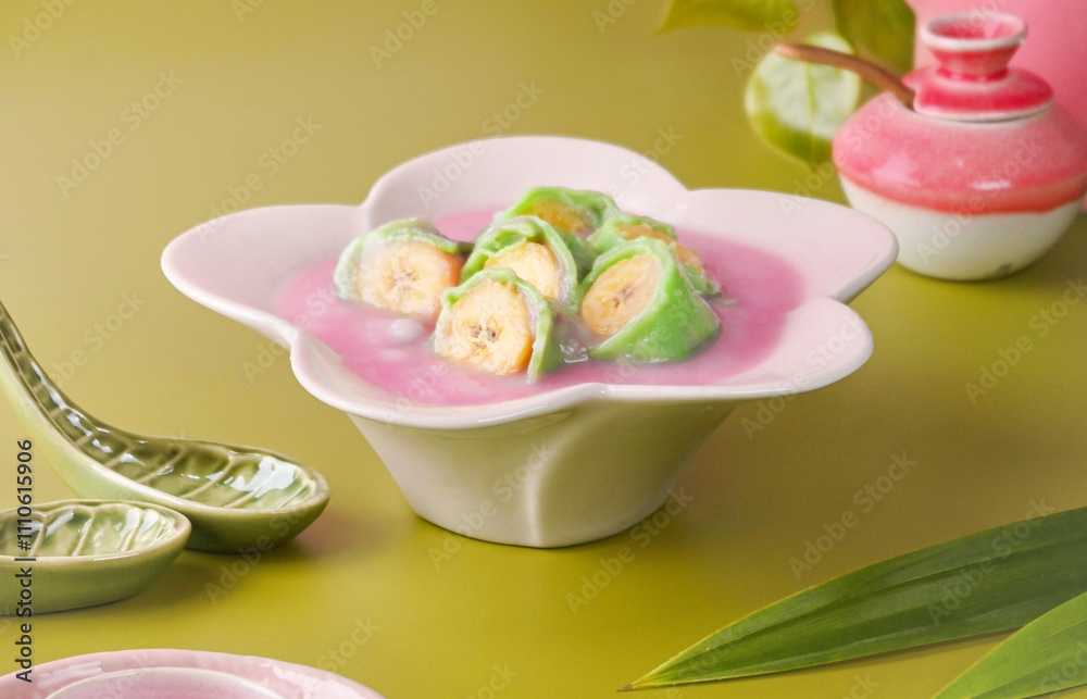 Es Pisang Ijo is a Makassar dessert of bananas wrapped in green rice flour dough, served with sweet coconut sauce, syrup, and ice. Es Pisang Ijo is a Makassar dessert of bananas wrapped in green rice flour dough, served with sweet coconut sauce, syrup, and ice.