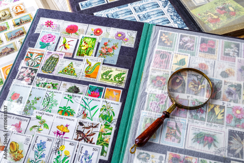 Philately.Collection of stamps and magnifying glass.Spring themed stamp collection.A page of storage book album for storing old postage stamps. Philately.Collection of stamps and magnifying glass.Spring themed stamp collection.A page of storage book album for storing old postage stamps.