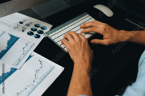Smart businessman analyzing business paragraph dynamic database marketing analysis plan surrounded paper sheet and pc monitor report to compare with document data at home office at night. Pecuniary.