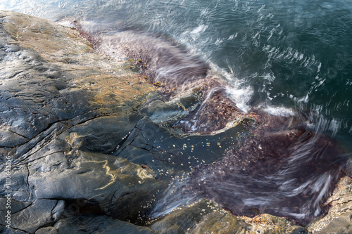 waves washing over rugged rocks under the surface. Taken with a slow shutter photo