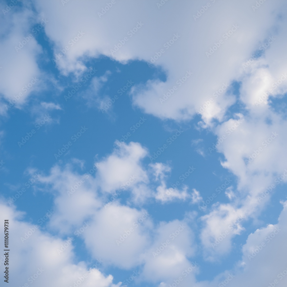 Obraz premium Low angle view of a clear blue sky and fluffy clouds in the background.