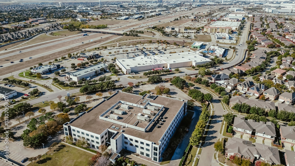 Fototapeta premium Commercial buildings, office space, grocery store, restaurants along Lyndon B Johnson Interstate I-635 freeway with new construction residential neighborhood houses suburbs Dallas, Texas, aerial