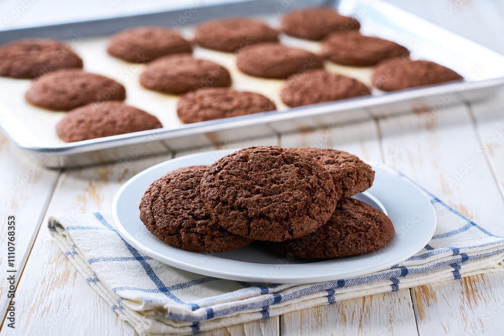 Close up of baking tray with chocolate brownie cookies with cracks on a white table. Close up of baking tray with chocolate brownie cookies with cracks on a white table.