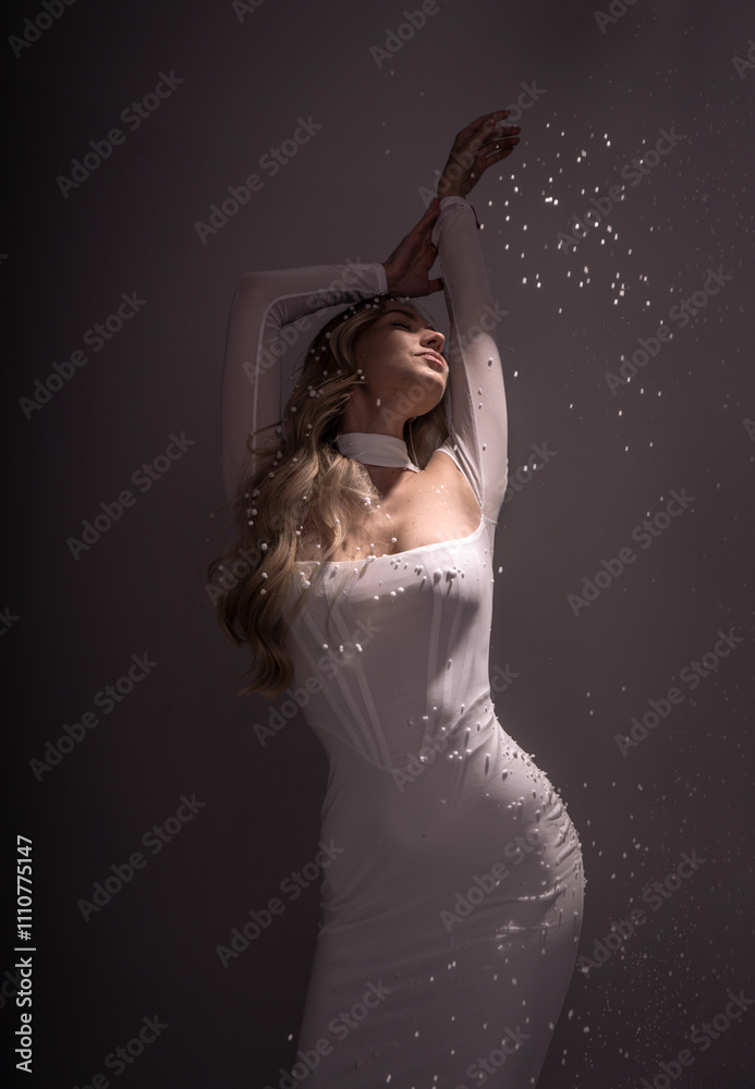 Fototapeta premium Studio shot of a girl in a white dress with artificial snow
