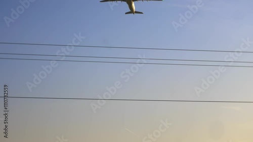 Airplane taking off with power lines in foreground on a clear day