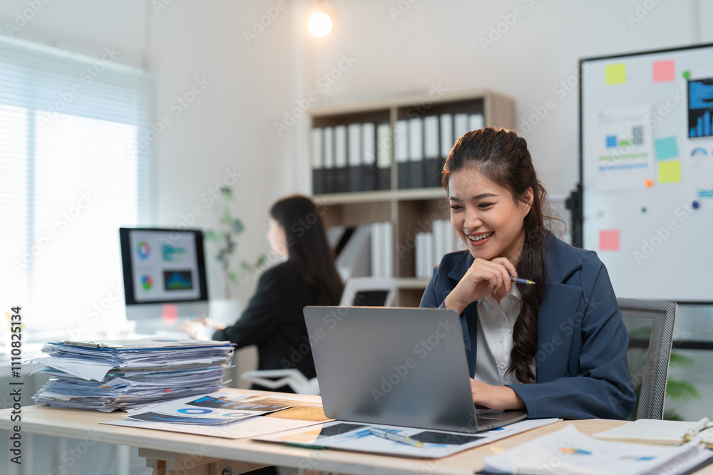 Happy businesswoman working with laptop computer, analyzing data, graphs and charts, making notes and preparing presentation in the office Happy businesswoman working with laptop computer, analyzing data, graphs and charts, making notes and preparing presentation in the office