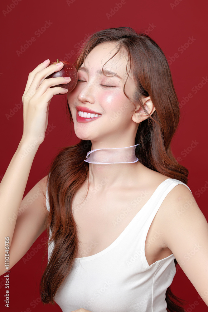 Young Asian Woman Holding Fresh Red Apple on Red Background. Young Asian Woman Holding Fresh Red Apple on Red Background.
