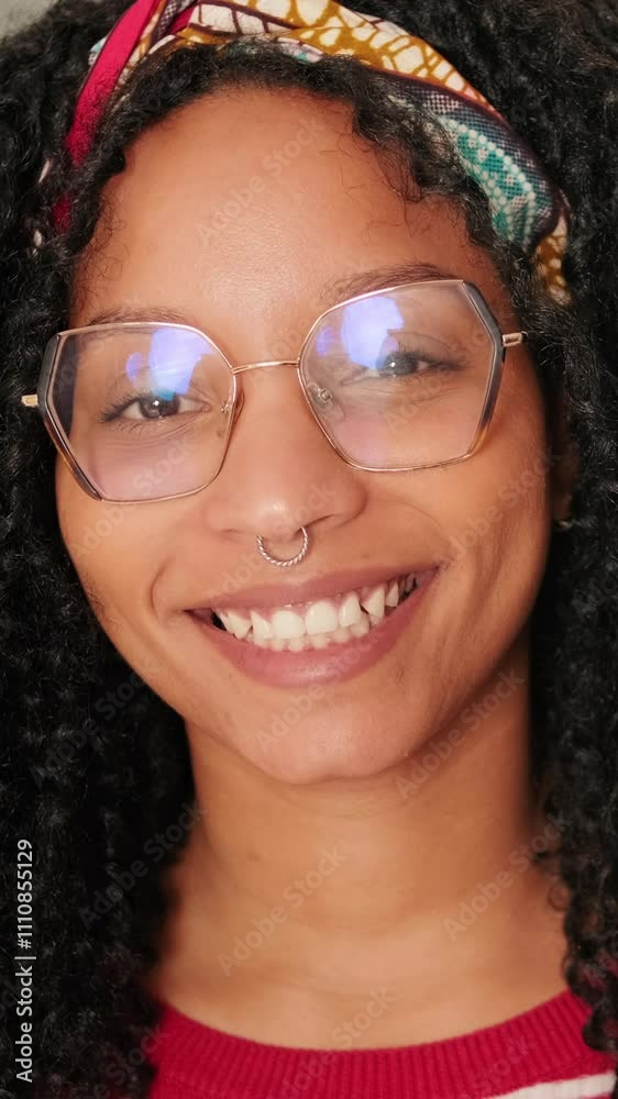 Smiling woman standing in living room looking at camera, camera zoom Smiling woman standing in living room looking at camera, camera zoom