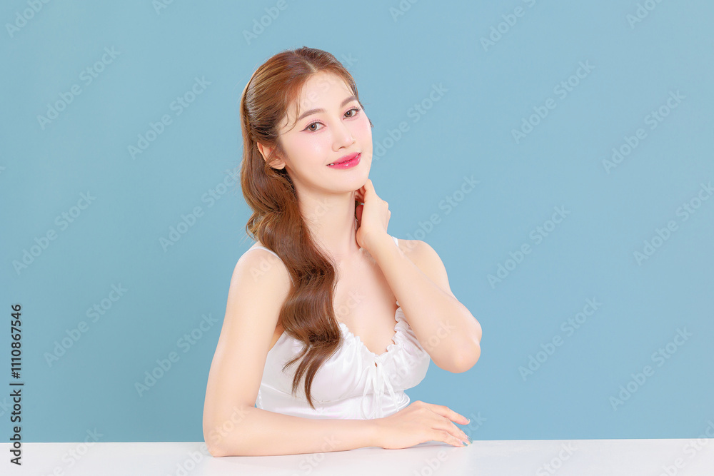 Pretty Asian beauty woman curly long hair with Korean makeup glowing face and healthy facial skin portrait smile on isolated blue background. Pretty Asian beauty woman curly long hair with Korean makeup glowing face and healthy facial skin portrait smile on isolated blue background.