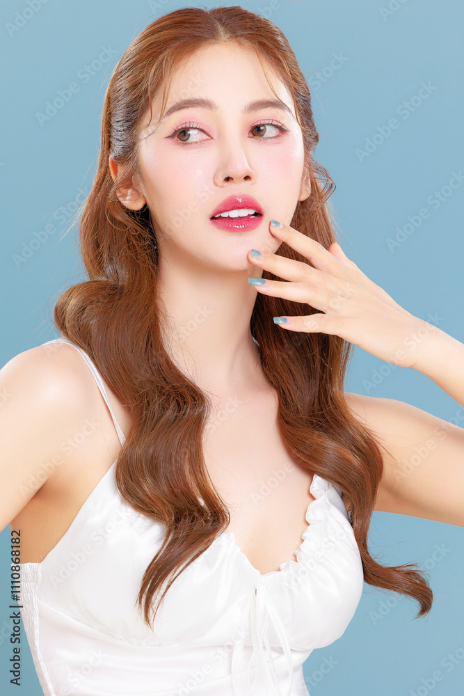 Pretty Asian beauty woman curly long hair with Korean makeup glowing face and healthy facial skin portrait smile on isolated blue background. Pretty Asian beauty woman curly long hair with Korean makeup glowing face and healthy facial skin portrait smile on isolated blue background.