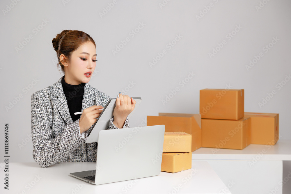 Asian smart entrepreneur business woman in casual suit surround by parcel boxes using computer laptop internet service customer online marketing check package in home store. SME concept. Asian smart entrepreneur business woman in casual suit surround by parcel boxes using computer laptop internet service customer online marketing check package in home store. SME concept.