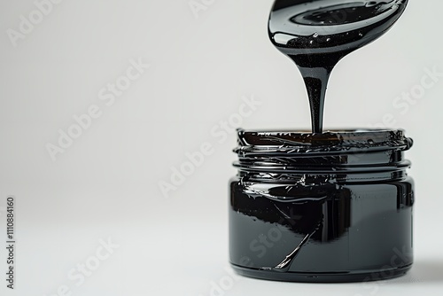 A close-up of a jar of shilajit and a spoon next to it with space for backdrop use on a spotlessly white studio background, Generative AI.