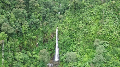 Aerial shot of Curug Cijalu ,beautiful hidden waterfall in green forest. Tropical mountain jungle waterfall in the tropical forest. Nature background photo