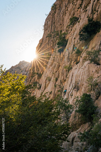 landscape of the mountains, climber in the wall, beautiful sun lens flare, multi pitch, climbing, croatia, paklenica, national park, alpinism