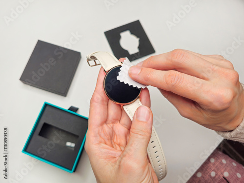 woman hands cleaning smart watch on white table