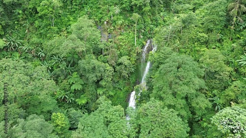 Aerial shot of Curug Cijalu ,beautiful hidden waterfall in green forest. Tropical mountain jungle waterfall in the tropical forest. Nature background photo