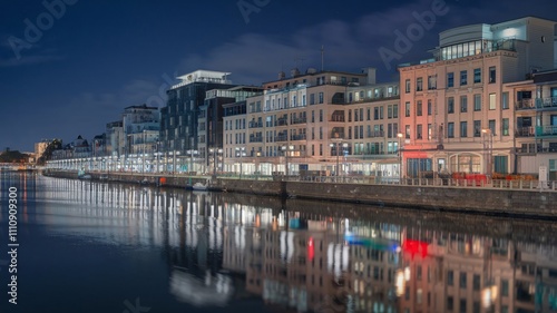 Night View of Busy Waterfront Promenade with Glowing City Reflections