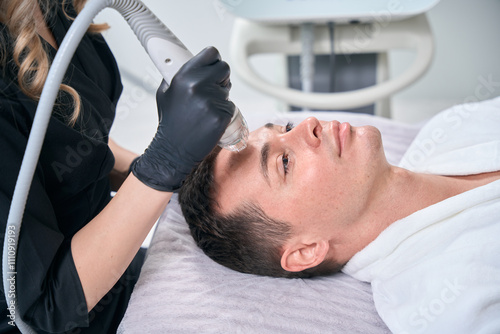 Man attending microneedle rf lifting procedure in aesthetic cosmetology clinic