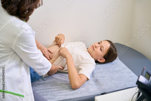 Medical worker examines the belly of a girl photo