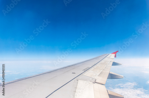 View from the airplane window at a beautiful cloudy sky and the airplane wing