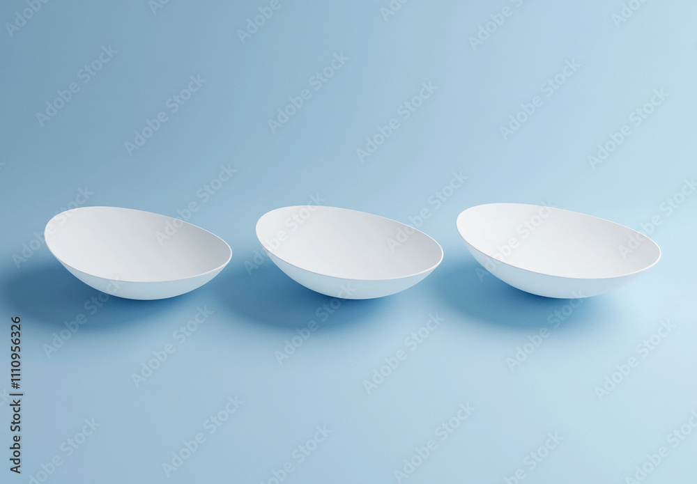 Three minimalistic white bowls arranged on a light blue background for modern kitchen decor Three minimalistic white bowls arranged on a light blue background for modern kitchen decor