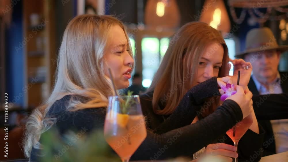 Two friends enjoy cocktails at a restaurant, sharing laughs and selfies Two friends enjoy cocktails at a restaurant, sharing laughs and selfies