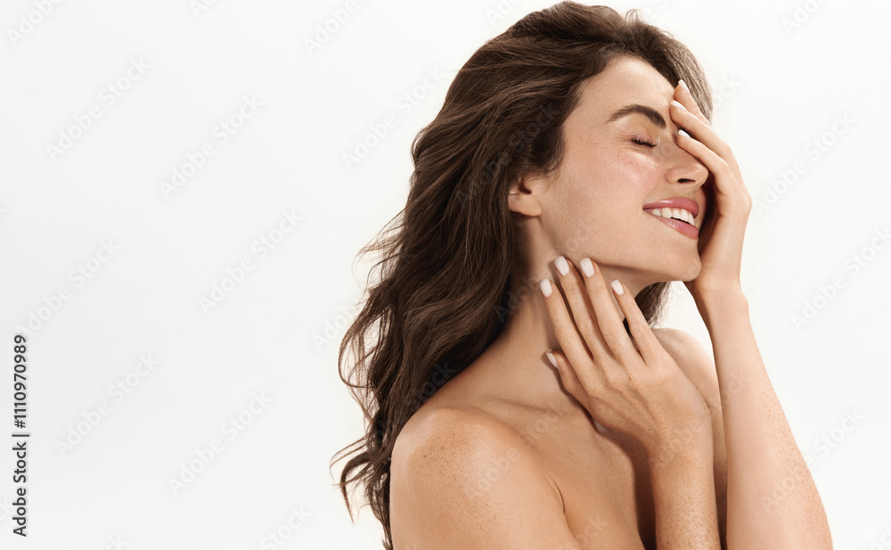 Natural Beauty Portrait of a Smiling Woman with Radian Glowing Skin and Flowing Hair, Posing with Romantic Smile against a Clean White Background. Model Touching Hydrated Flawless Skin Natural Beauty Portrait of a Smiling Woman with Radian Glowing Skin and Flowing Hair, Posing with Romantic Smile against a Clean White Background. Model Touching Hydrated Flawless Skin