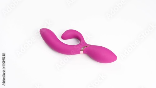 Pink vibrator spinning on white background.