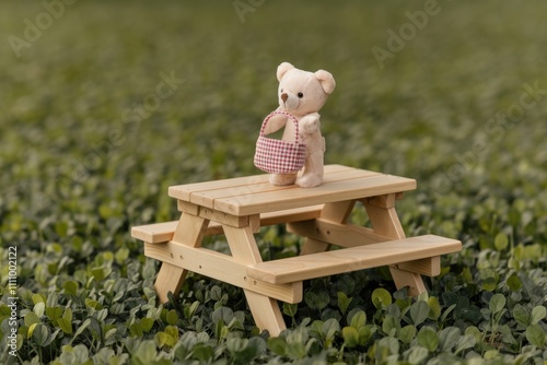 A teddy bear with a basket stands on a miniature picnic table surrounded by green foliage.