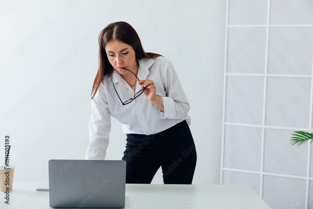 Business woman in glasses working online with laptop at desk Business woman in glasses working online with laptop at desk
