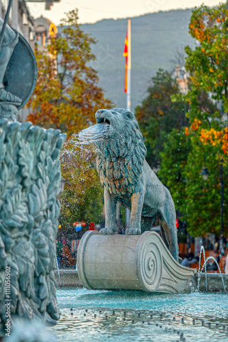 Majestic Lion Water Fountain Detail with Autumn Colors - Ornate Bronze Sculpture with Water Jets at Macedonia Square Monument, Downtown Skopje with Vodno Mountain View, North Macedonia photo