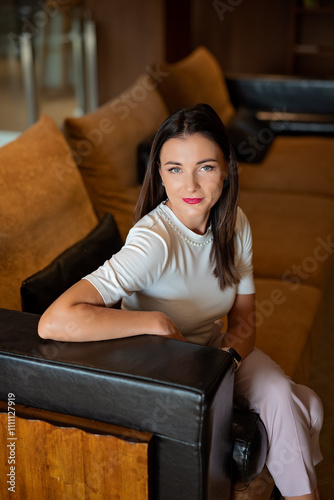 Smiling businesswoman sitting on a sofa in a cozy modern interior 3