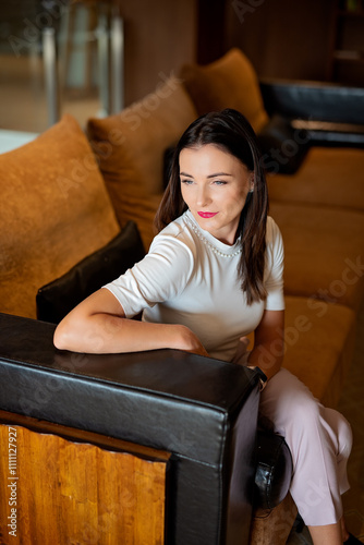 Smiling businesswoman sitting on a sofa in a cozy modern interior 2