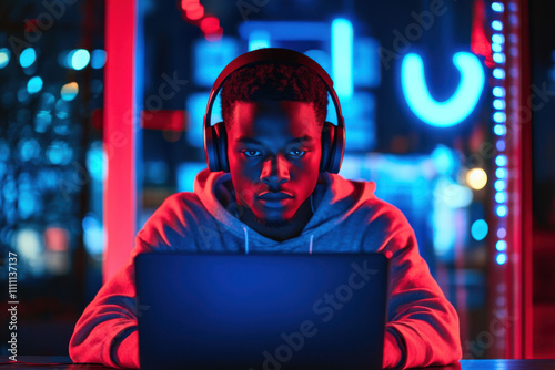 Black teenager gaming on a laptop in a café wearing headphones with blank space