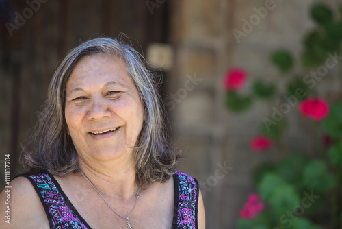 portrait of senior south America native  woman in her garden by her house  on sunny summer day  