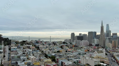 panning aerial footage of the bay bridge over ocean water, Coit Tower, skyscrapers and office buildings in the skyline in San Francisco California USA