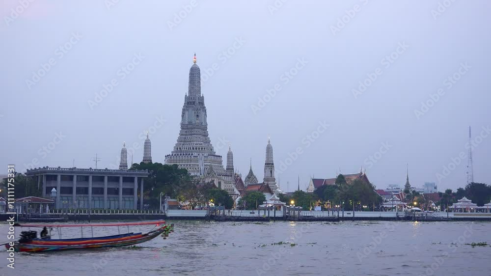 Bangkok, Thailand - January 22, 2018: Long boat sails on river in front of Wat Arun temple Bangkok