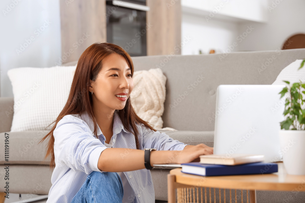Young Asian businesswoman working with laptop on table at home Young Asian businesswoman working with laptop on table at home