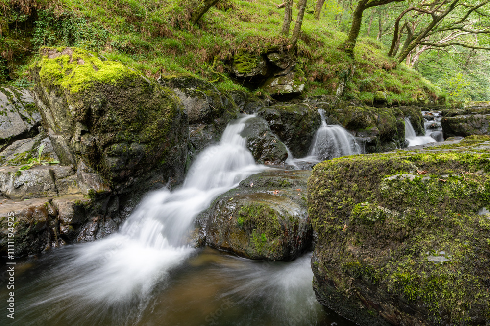 Fototapeta premium Long exposure of a waterfall on the East Lyn river at Watersmeet in Exmoor National Park