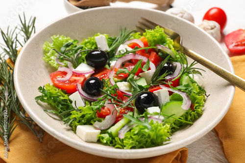 Bowl of tasty Greek salad on light table, closeup