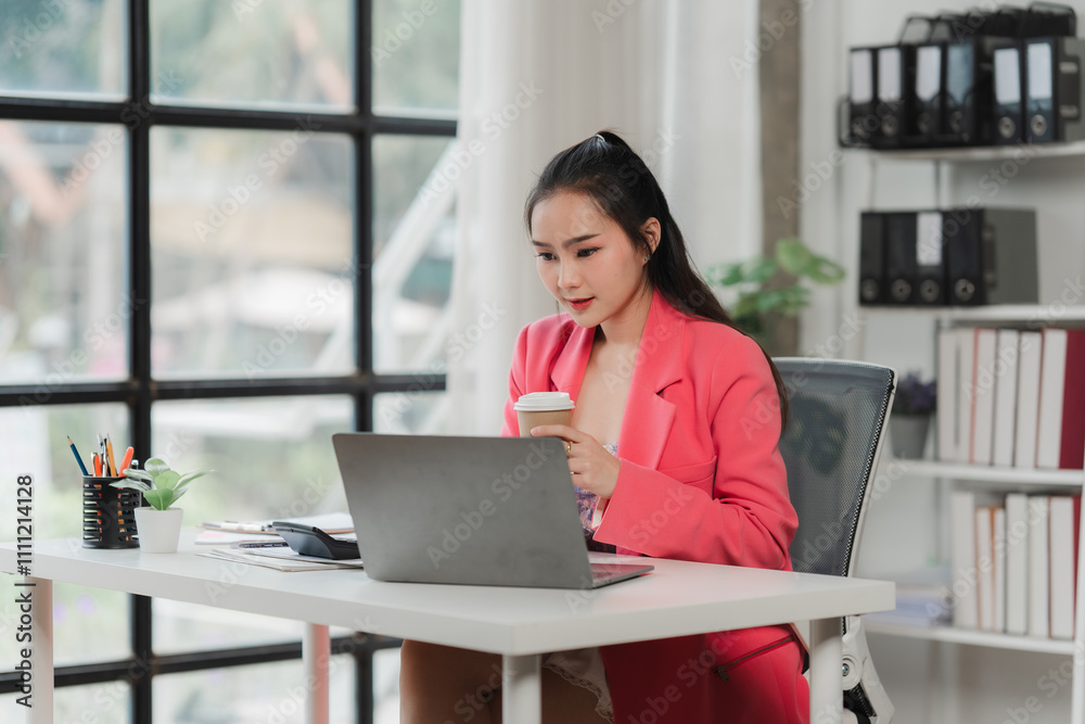 Focused Professional Woman Working on Laptop in Modern Office Focused Professional Woman Working on Laptop in Modern Office