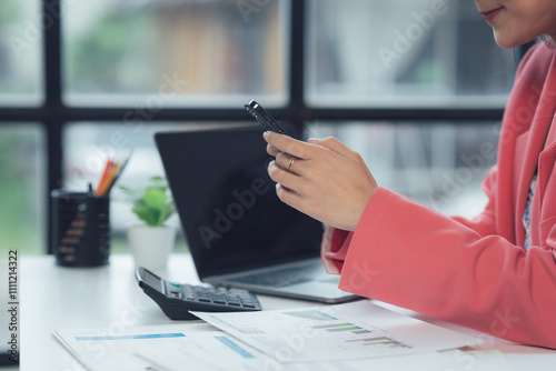 Focused Businesswoman Analyzing Data: A close-up shot of a businesswoman's hands meticulously reviewing financial documents and using a calculator.