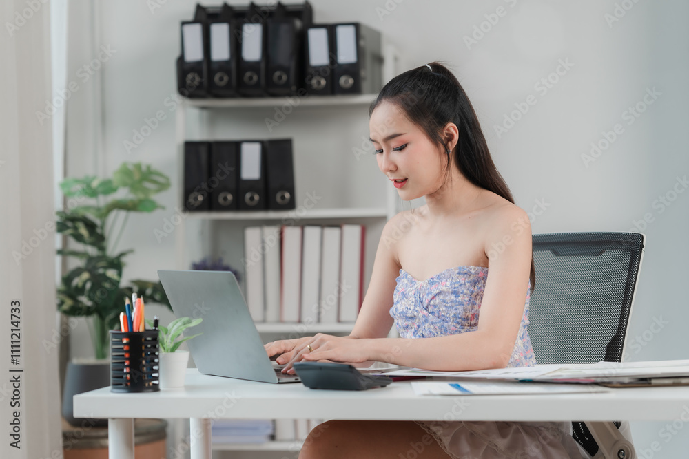 Focused and Efficient: Young businesswoman working diligently on her laptop in a modern office setting. The image captures the essence of professionalism, productivity, and dedication. Focused and Efficient: Young businesswoman working diligently on her laptop in a modern office setting. The image captures the essence of professionalism, productivity, and dedication.