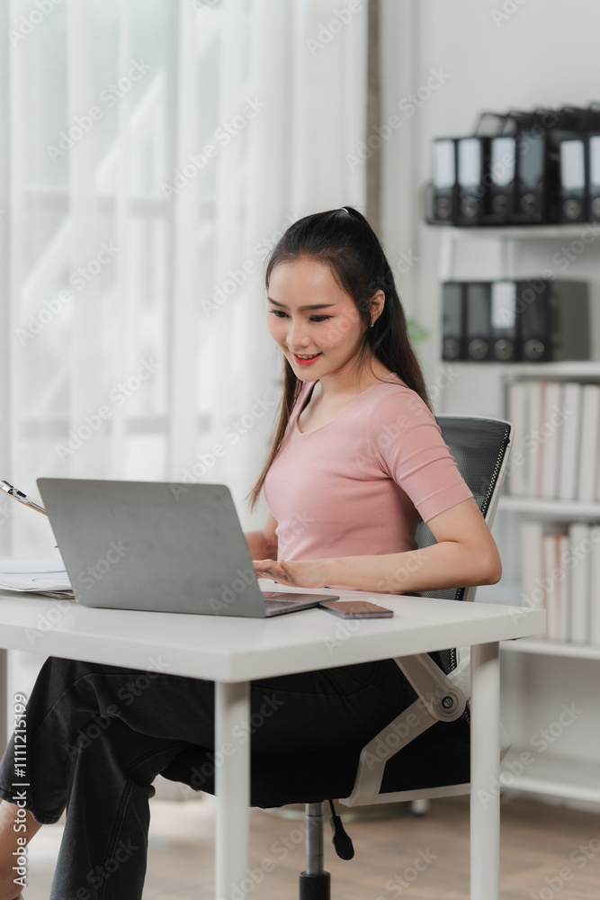 Focused and Empowered: A young professional woman exudes confidence as she works diligently on her laptop, showcasing a modern and dynamic approach to her career. Focused and Empowered: A young professional woman exudes confidence as she works diligently on her laptop, showcasing a modern and dynamic approach to her career.