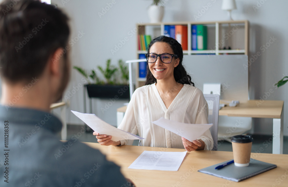 Searching for job concept. Happy human resources manager speaking to employment applicant on work interview, holding CV at office. Personnel manager talking to vacancy candidate Searching for job concept. Happy human resources manager speaking to employment applicant on work interview, holding CV at office. Personnel manager talking to vacancy candidate